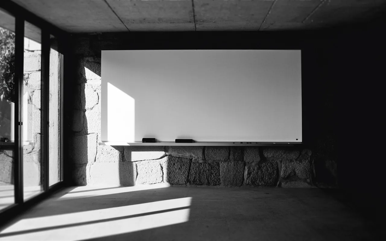 Aula de formación con encerado en un espacio de piedra y luz natural