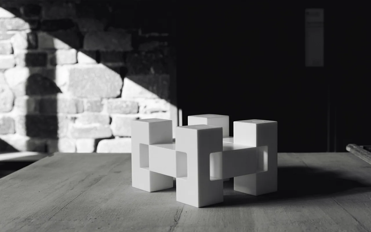 Piezas geométricas blancas entrelazadas sobre una mesa de madera